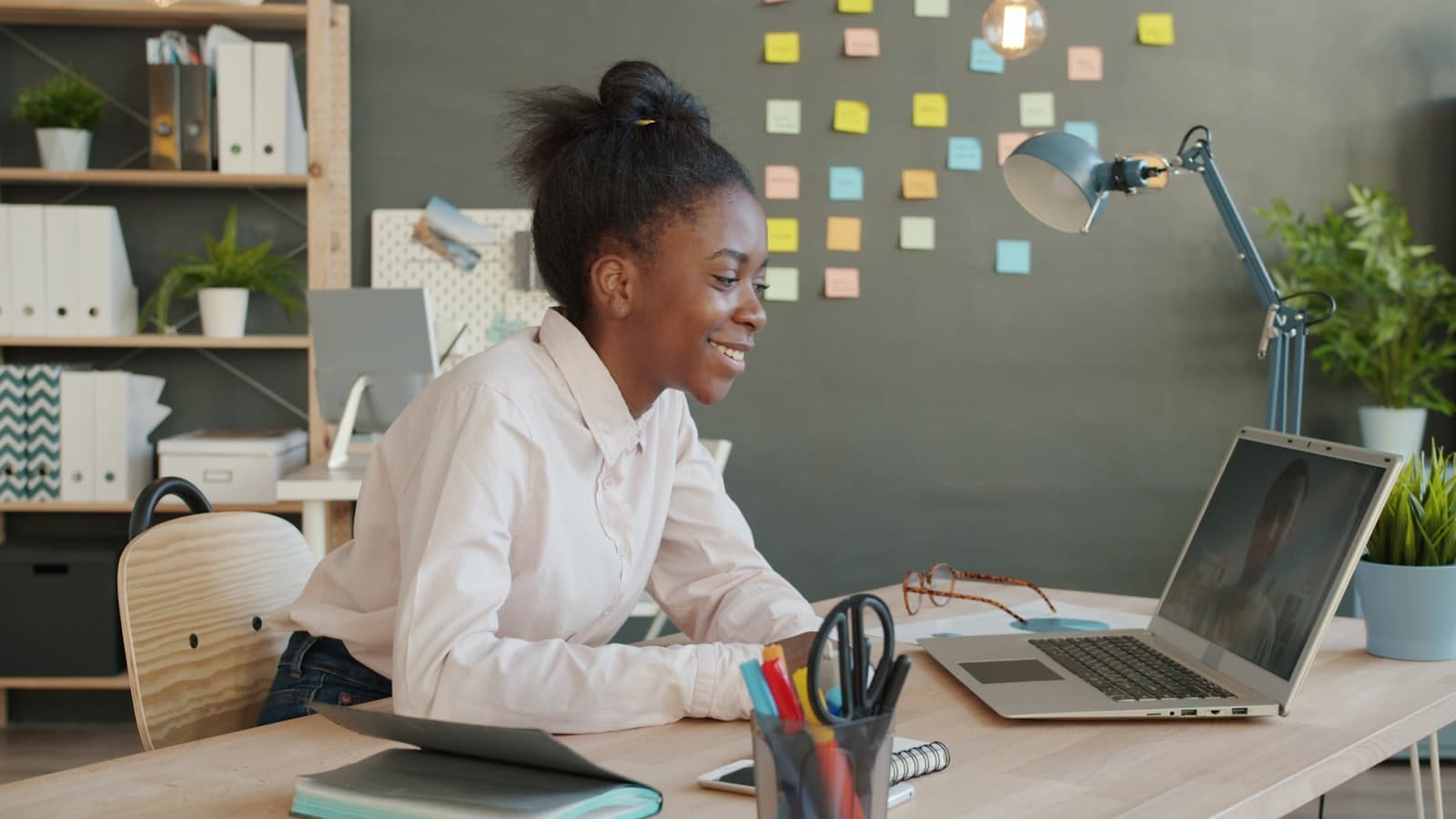 A student on a video call on a laptop at a home desk