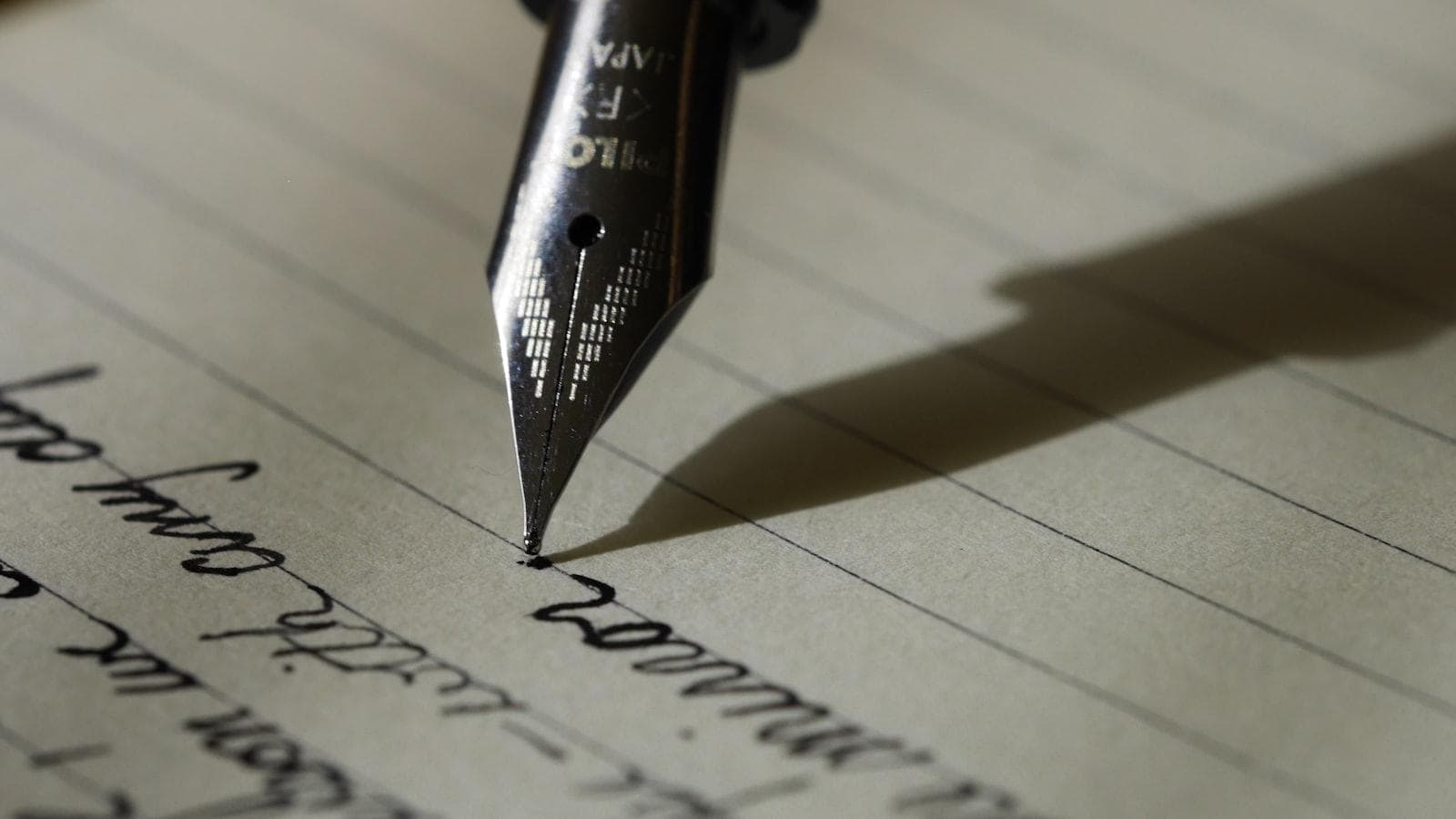 A fountain pen writing an essay on lined paper